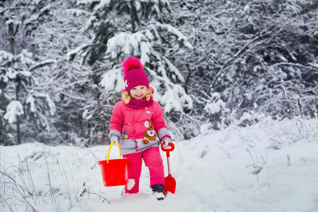 Kid joyfully engaged in a snow scavenger hunt, searching for winter-themed treasures in the snowy landscape. Experience the magic with Our Days Calendar. #OurDaysSnowHunt